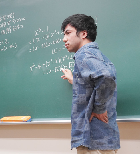 黒板に数式を書きながら説明するスタッフ