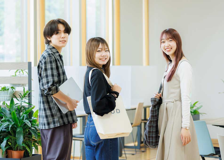 学習支援コモンズで談笑する3人の学生